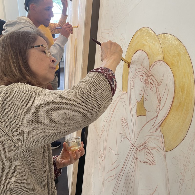 Une iconographe peint le halo doré de l'icône de la Visitation.